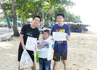 Two Chinese gentlemen and Phu are helping to clean trash off Jomtien Beach.